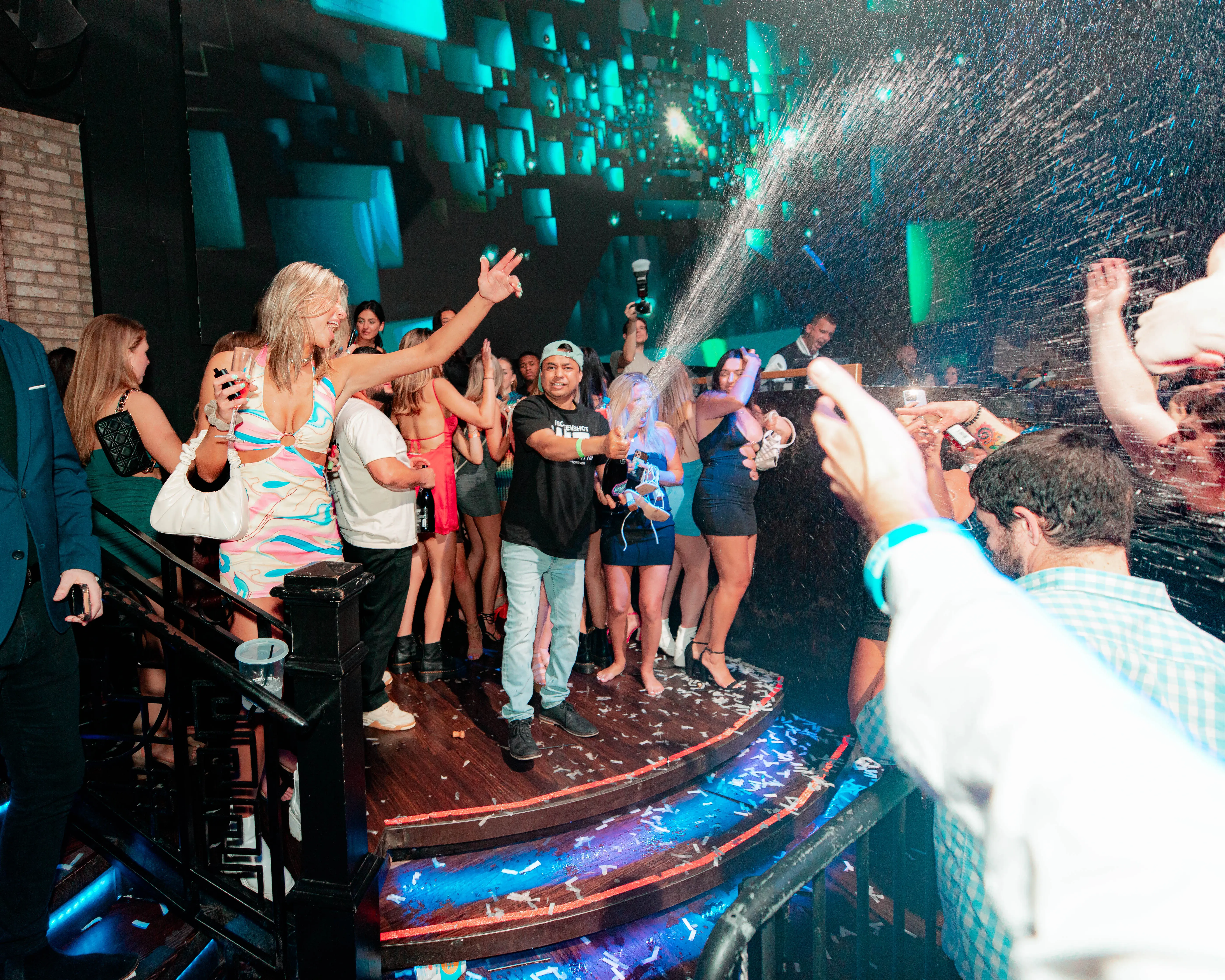 Confetti bursting over dancers celebrating on a club stage
