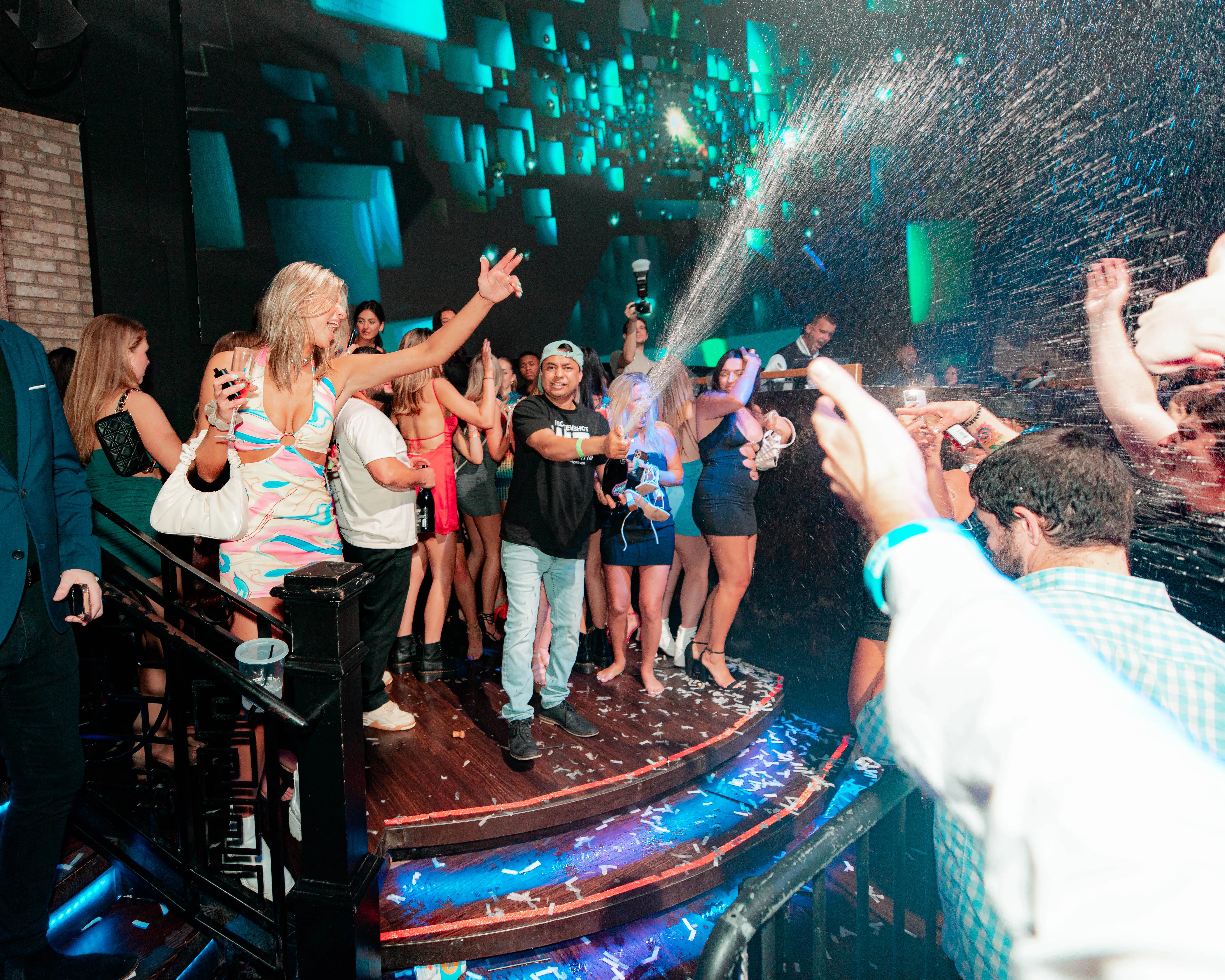 Confetti bursting over dancers celebrating on a club stage